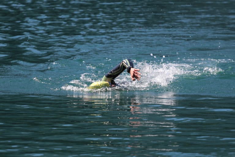 Triathlète nageant dans un lac avec une combinaison de triathlon