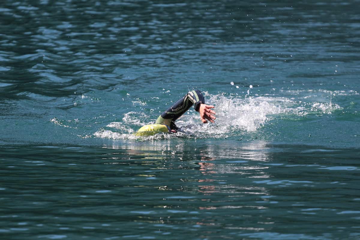 Triathlete swimming in a lake with a wetsuit